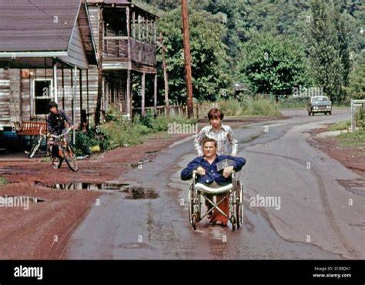 Disabled Miner Wheeled By His Daughter