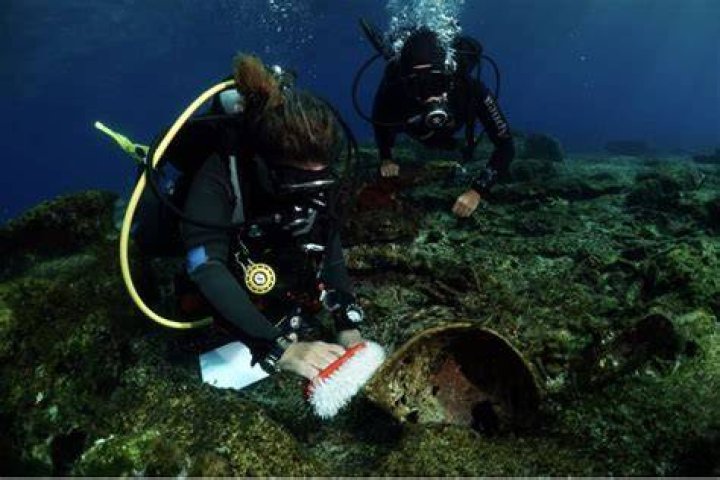 Divers Examining Artifacts Near Greece
